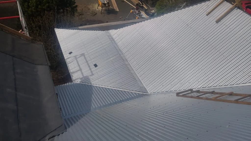Samskeyti og rennur á nýju ljósu báruþaki.