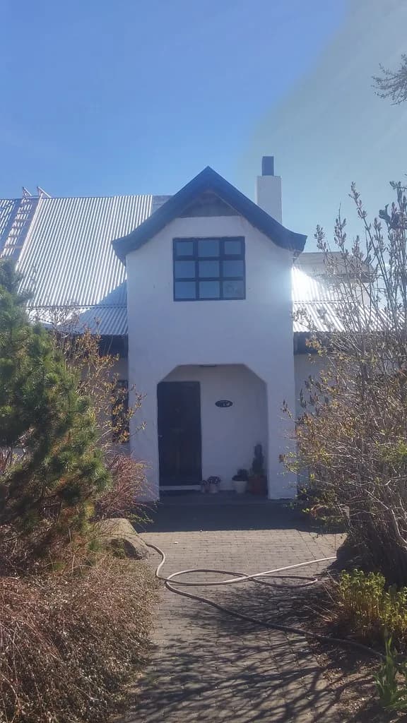 Gaflkvistur og inngangur undir nýju ljósu málmþaki.