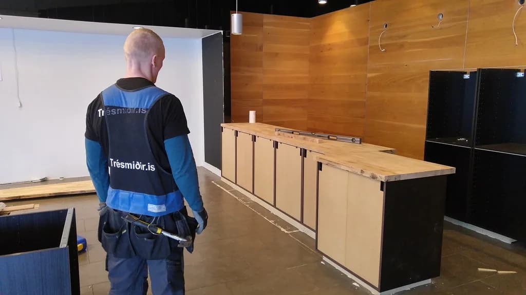 Smiður skoðar skápainnréttingu í smíðum.
