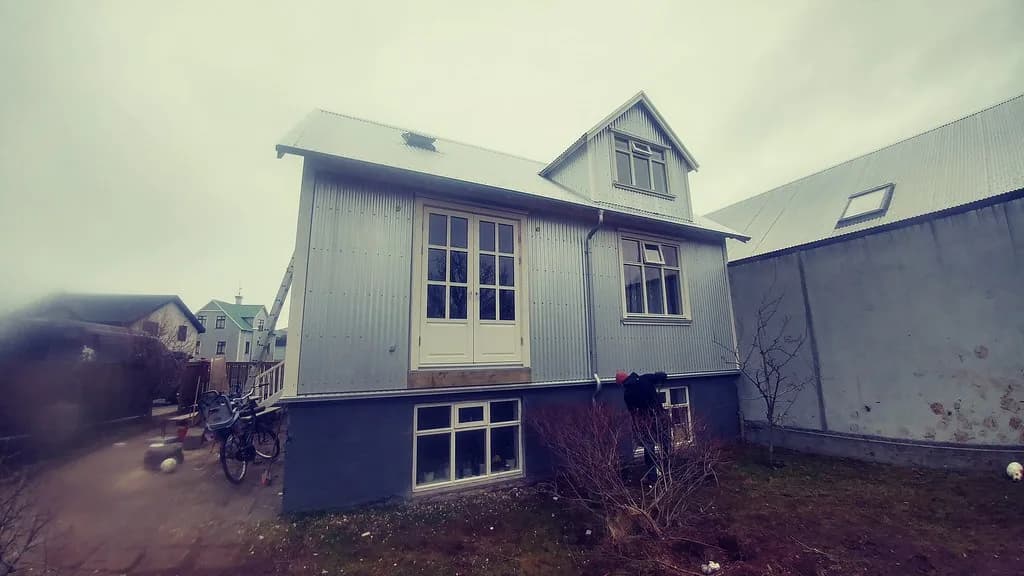 Timburhús með ljósri útveggsklæðningu og gluggakvisti.