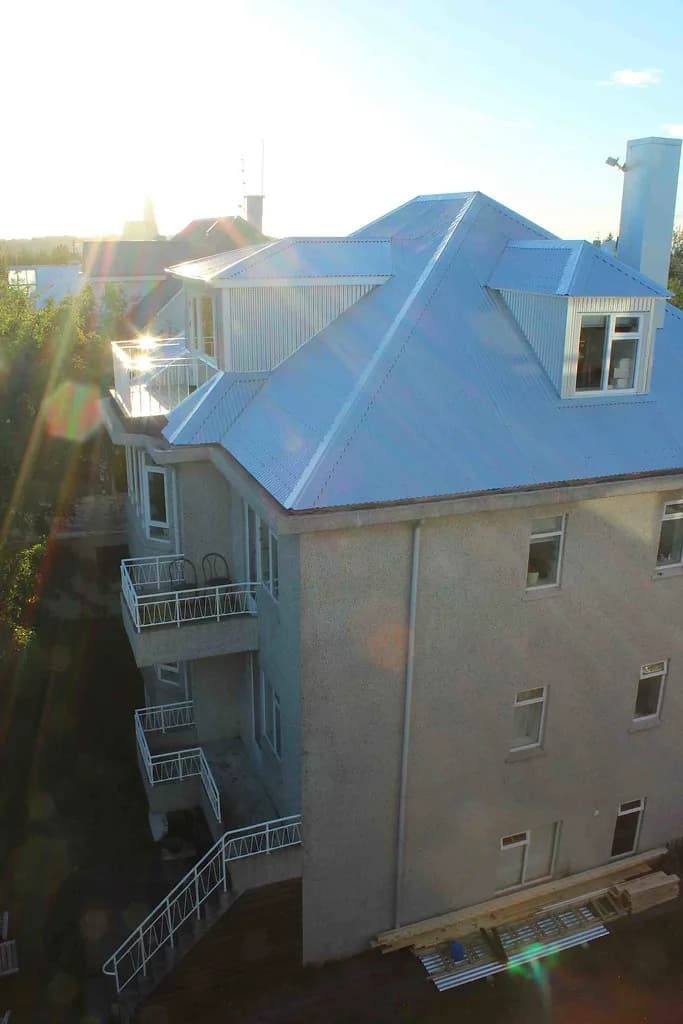 Málmklætt þak með kvistum á fjölbýlishúsi, séð ofan frá.