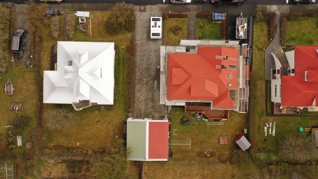 Loftmynd af tveimur húsum með ljósu og rauðu þaki.
