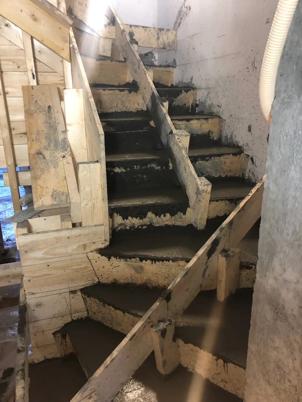 Sveigður steyptur stigi með timburmótum.