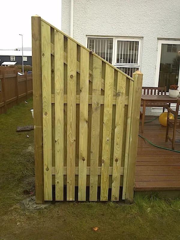 Lóðréttur timburskjólveggur við pall og húsvegg.